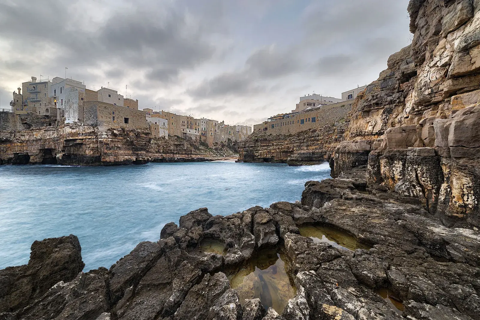 Lama Monachile fotografata a pelo d’acqua, con la falesia e il ponte sullo sfondo