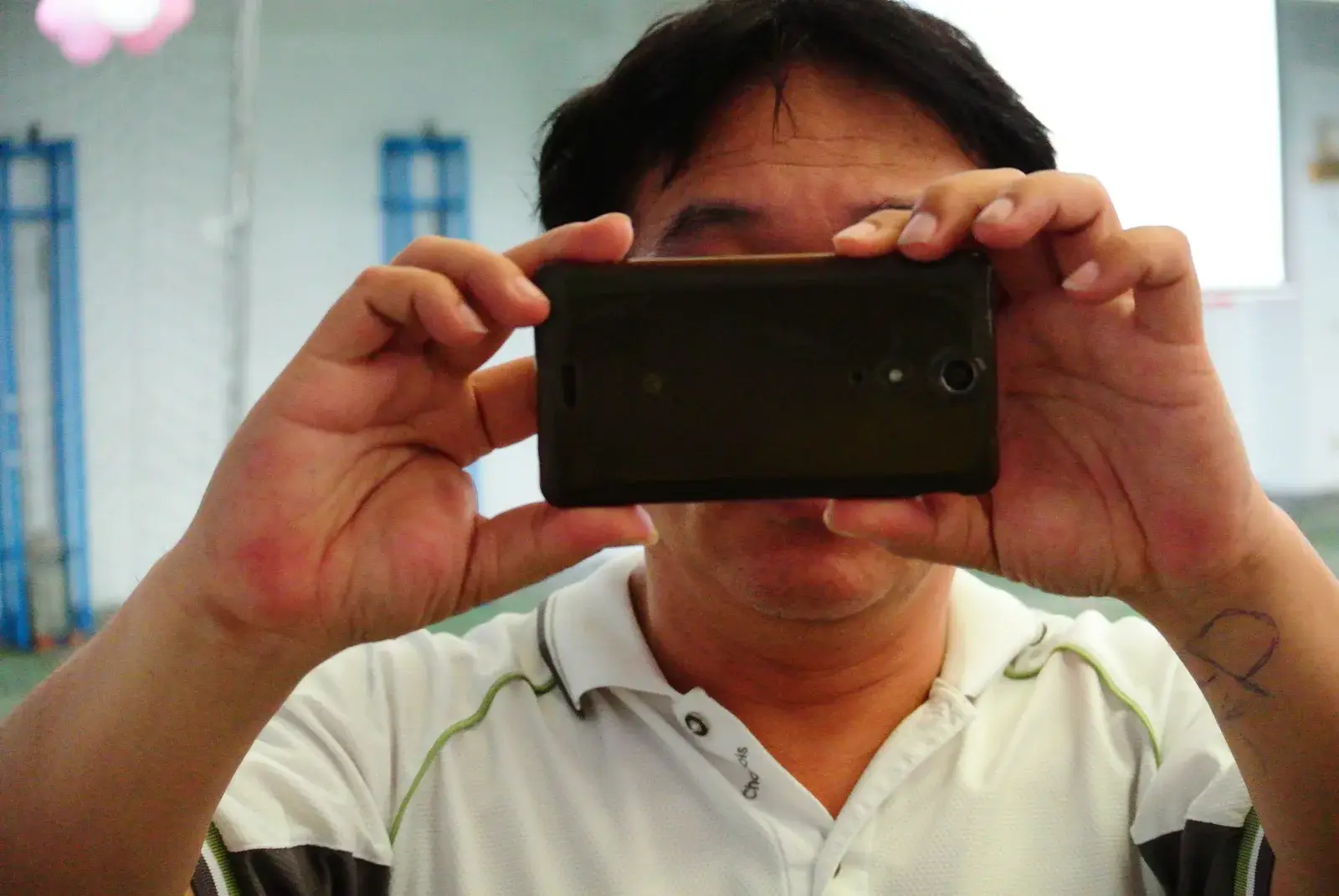 Un uomo scatta una foto tenendo lo smartphone con due mani