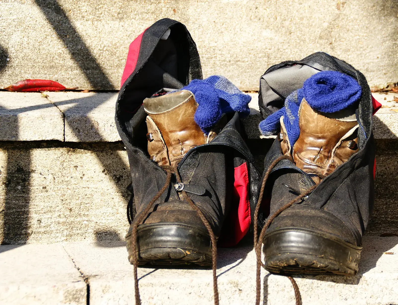 Un paio di scarponi da trekking consumati con le calze appoggiate sopra