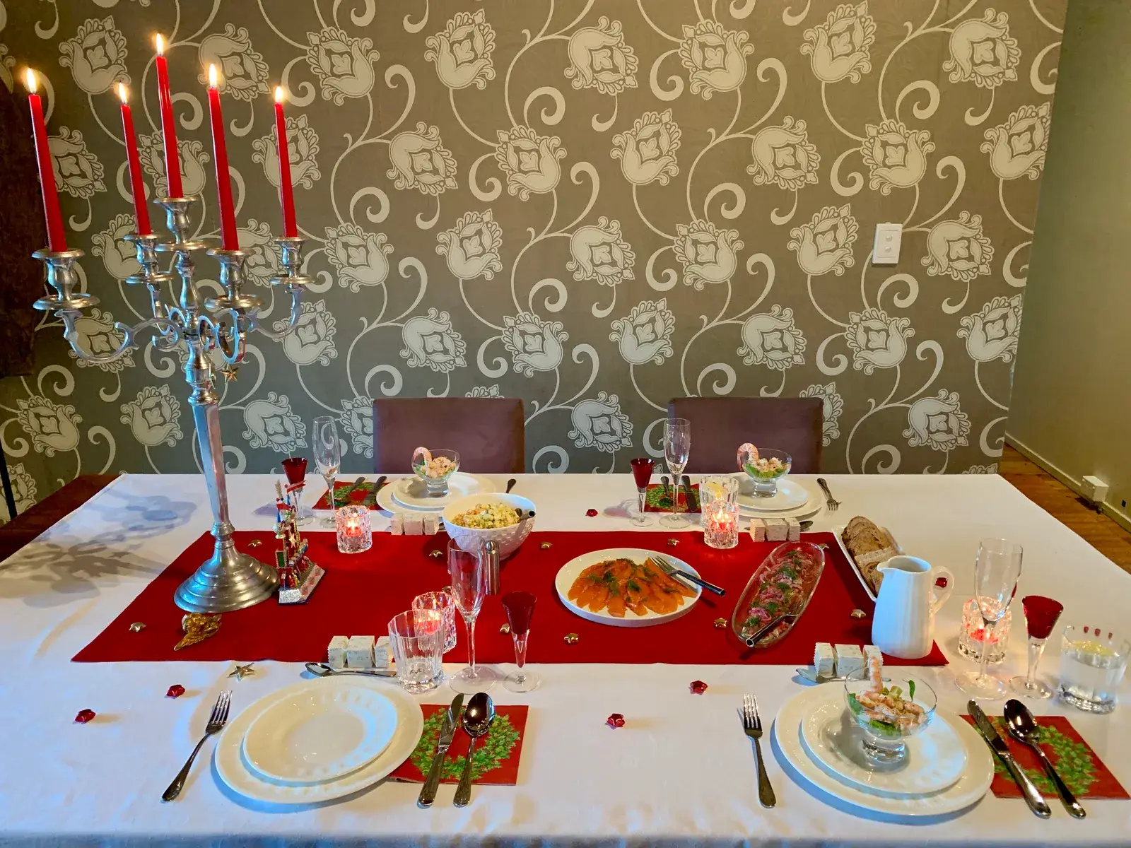 Tavola apparecchiata per la cena della vigilia con candelabro e tovaglia rossa