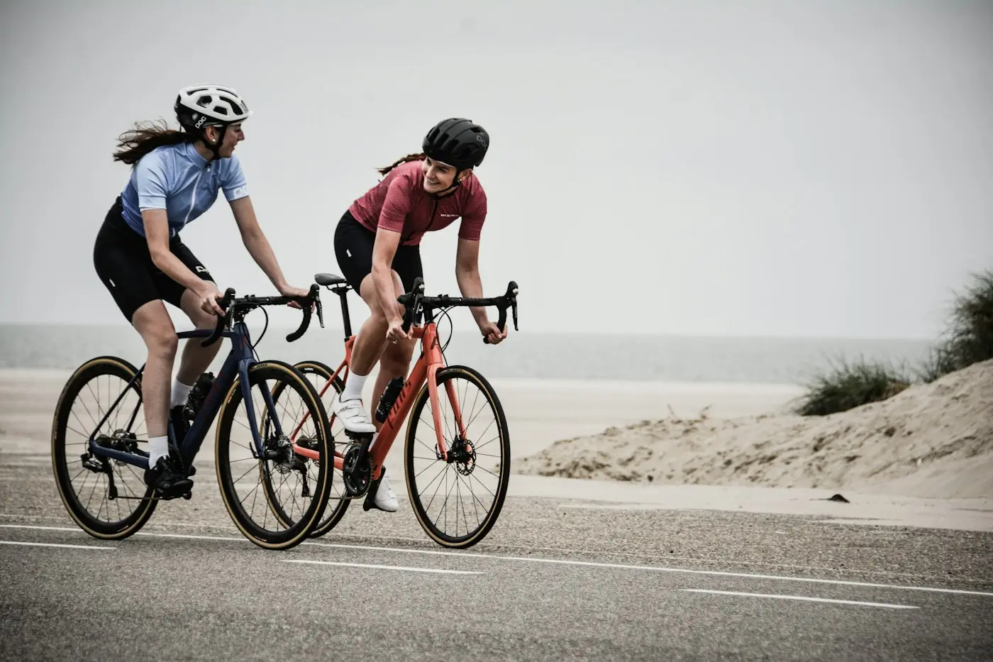 Due cicliste in bici da corsa lungo la costa