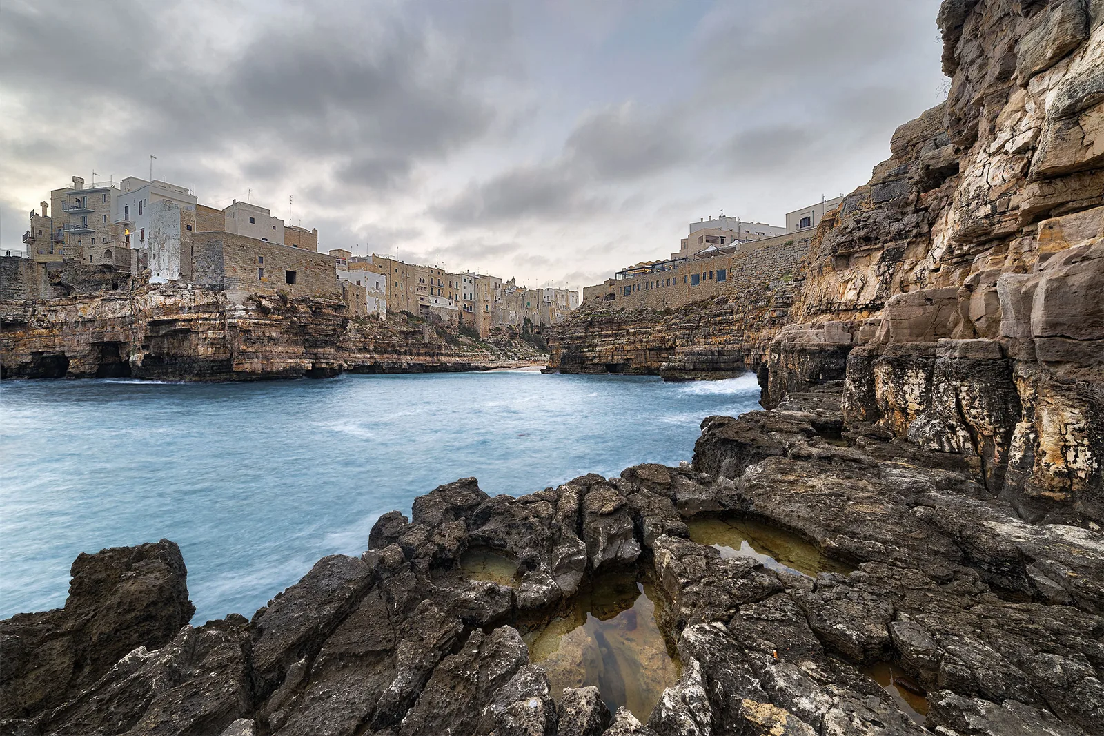 Lama Monachile fotografata a pelo d’acqua, con la falesia e il ponte sullo sfondo