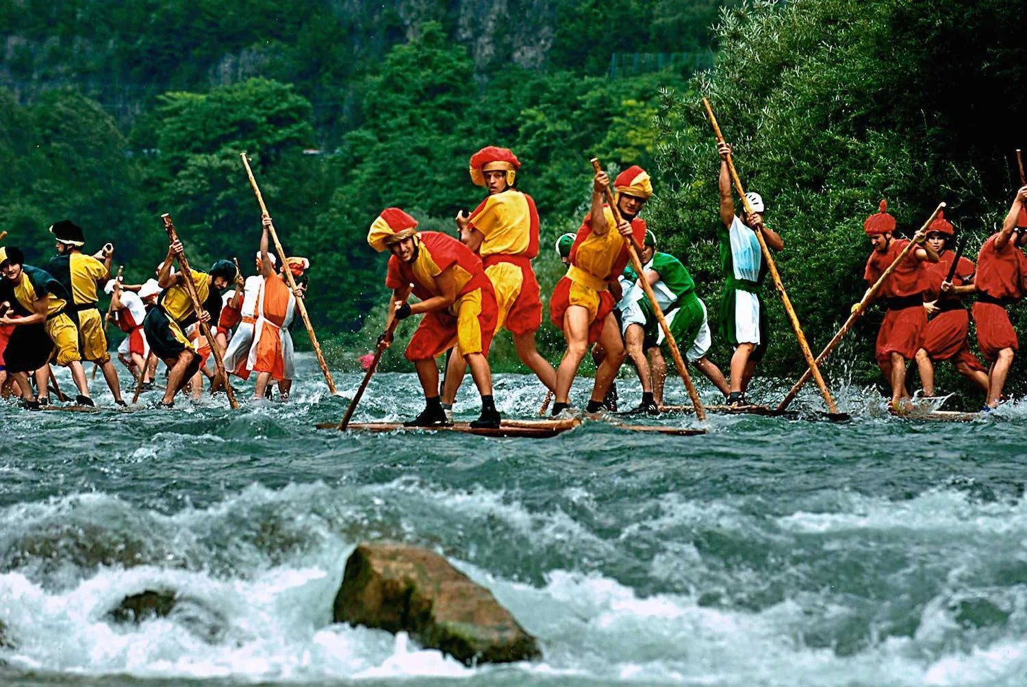 Zattere di tronchi con equipaggi in costume storico scendono le rapide del Brenta a Valstagna