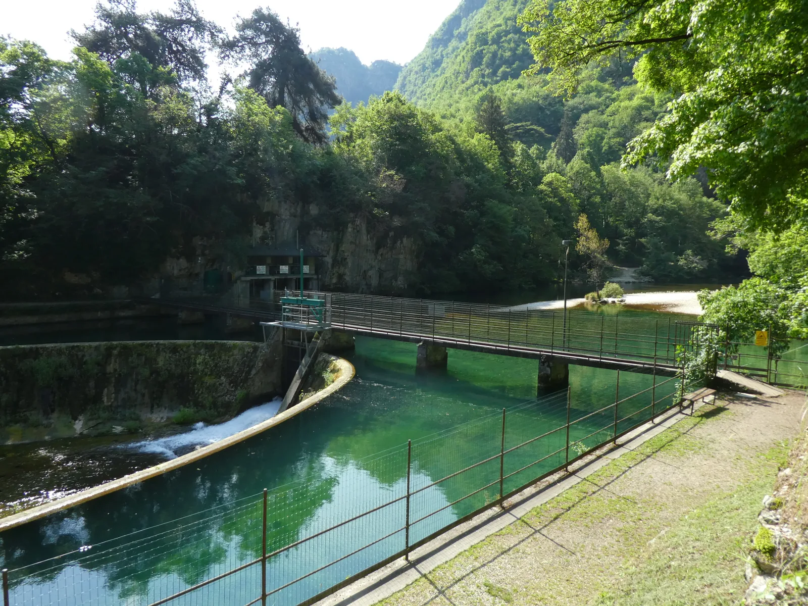 Lo specchio d’acqua verde delle risorgive nel parco delle Grotte di Oliero
