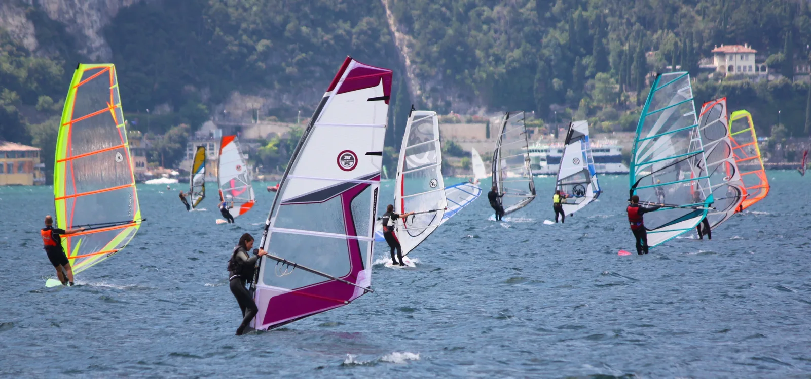 Vele da windsurf sul lago di Garda con le montagne sullo sfondo
