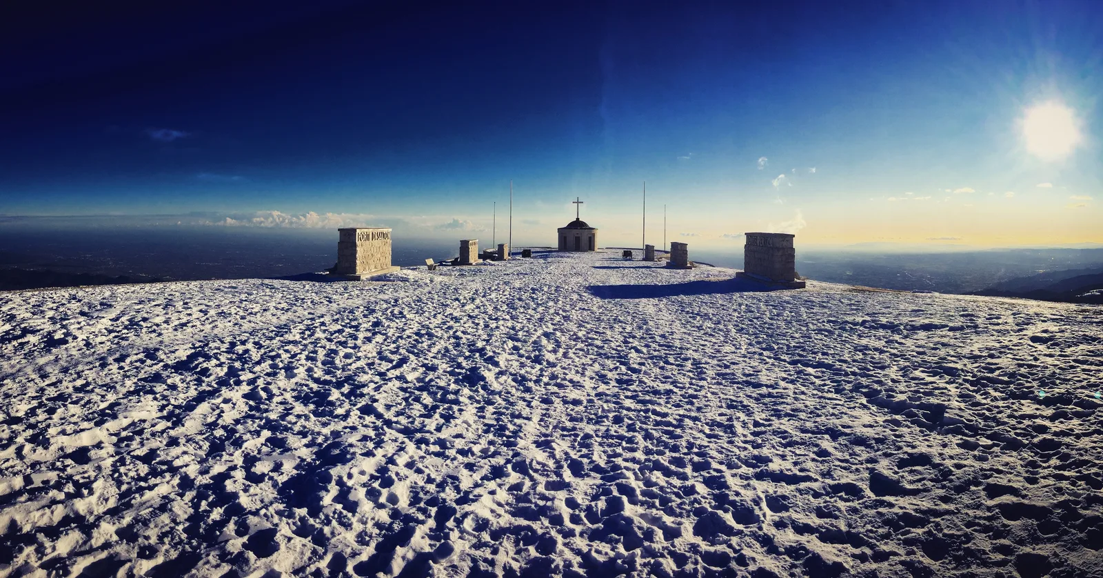 Cima Grappa innevata con il Sacrario militare e la pianura veneta sullo sfondo
