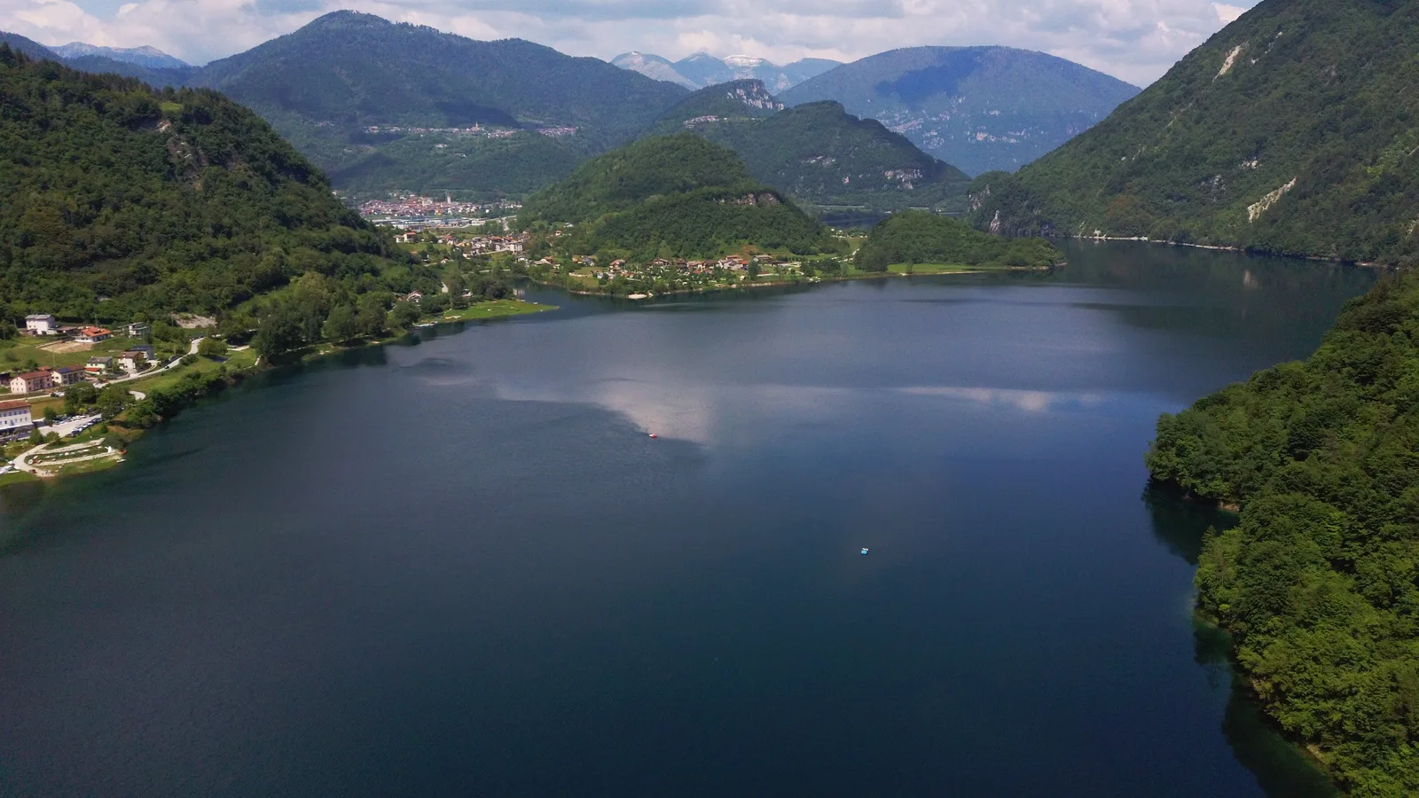 Veduta aerea del Lago di Corlo ad Arsiè, stretto fra due versanti boscosi